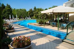 a swimming pool with chairs and a table and a bench at Hotel Grand Torino in Abano Terme