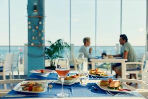 una mesa con platos de comida y una copa de vino en TUI MAGIC LIFE Masmavi, en Belek