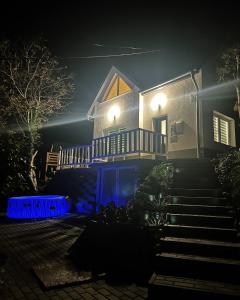 una casa por la noche con luces azules en las escaleras en Tóvölgy Privát Vendégház en Pécsvárad