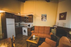 a living room with a couch and a kitchen at Casa Rural Puerta del Sol II de 2 habitaciones in Candelario +9 photos