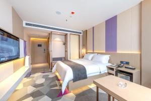 a hotel room with a bed and a flat screen tv at Lavande Hotel Chaoshan International Airport in Chaozhou