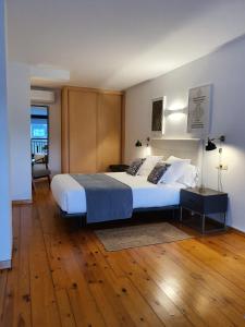 una camera con un grande letto e un pavimento in legno di Apartamentos Ciudad Santiago a Santiago de Compostela