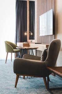 a hotel room with chairs and tables and a television at Bristol Hotel Podgorica in Podgorica