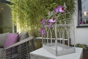 a metal bird cage with purple flowers on a table at Hostal Emeritae in Mérida
