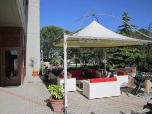 a white umbrella with people sitting under it at La Dimora di Federico in Gravina in Puglia