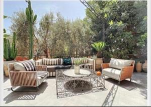 a patio with a couch and chairs and a table at Dartus in Tamraght Ouzdar