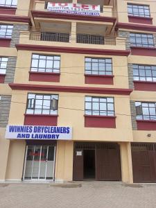 a building with a sign that reads winelines departments and laundry at lexy homes in Ruiru