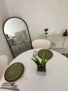 a table with two green plates and a mirror at T3 Moulin à vent proche UPVD in Perpignan