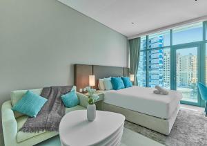 a hotel room with a bed and a couch at First Class Apartments in Seven Palm with direct Access to the West Palm Beach and Nakheel Mall in Dubai