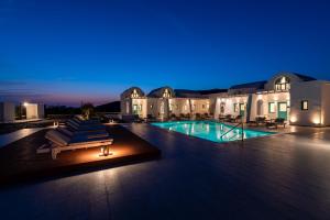 un complexe avec une piscine ouverte la nuit dans l'établissement Santa Irina Luxury Sunny Lofts, à Perivolos