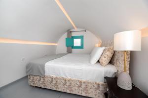 a bedroom with a bed and a lamp at Santa Irina Luxury Sunny Lofts in Perivolos