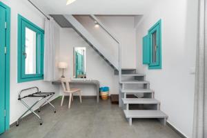 a staircase in a room with a desk and a chair at Santa Irina Luxury Sunny Lofts in Perivolos