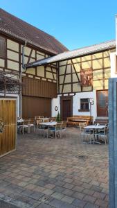 a patio with tables and chairs in a building at Ferienwohnung „Lochbach“ in Bad Mergentheim