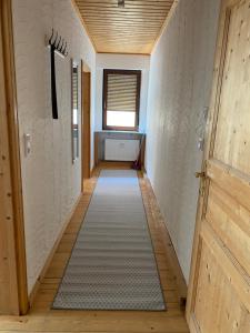 un pasillo con una puerta y una alfombra en Ferienwohnung „Lochbach“, en Bad Mergentheim