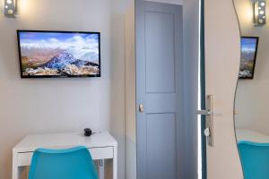 a room with a white table and a tv on the wall at Paris Legendre in Paris