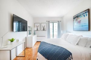 a white bedroom with a large bed and a table at Beautiful 1 BR Apartment in Columbus Avenue in New York