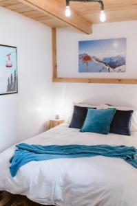 a bedroom with a large white bed with blue pillows at Le Grizzli Orford in Orford