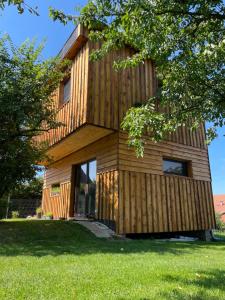une maison en bois sur une pelouse avec un arbre dans l'établissement Bydlení v zahradě, à Bratronice