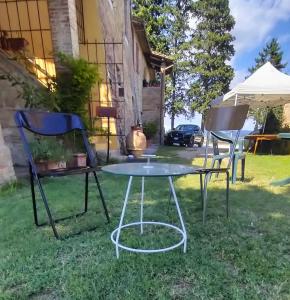 CollestradaにあるIl Fortino di San Francescoの草の中の椅子2脚とテーブル