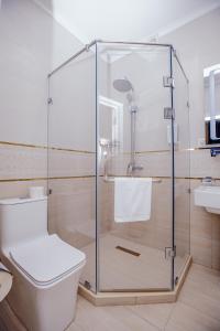 HOTEL SILK ROAD EMPIRE SAMARKAND في سمرقند: دش زجاجي في حمام مع مرحاض
