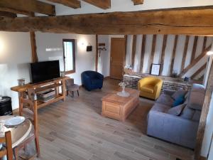 sala de estar con sofá y TV en Gîte de la giroterie, maison à la campagne au calme, vue sur la vallée, 