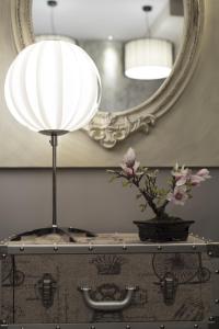 a lamp and a vase on a table with a mirror at Hostal Emeritae in Mérida