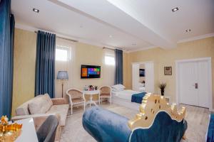 HOTEL SILK ROAD EMPIRE SAMARKAND في سمرقند: غرفة معيشة مع سرير وأريكة
