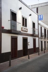 a white building with a sign on the side of it at Hostal Emeritae in Mérida