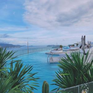 a swimming pool with a view of the water at SeaScape Panorama Grand Resicedences Nha Trang in Nha Trang
