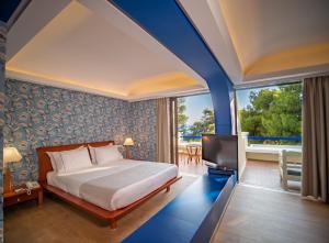 A bed or beds in a room at Ramada Loutraki Poseidon Resort