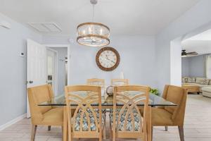 uma sala de jantar com uma mesa de vidro e cadeiras em Charming Family Retreat Heated Pool Private Yard em Cape Coral