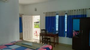 - une chambre avec un lit, un bureau et une porte dans l'établissement Nest, à Cochin