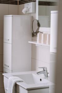a white bathroom with a sink and a mirror at Hotel Garni Familie Gruber in Spital am Pyhrn