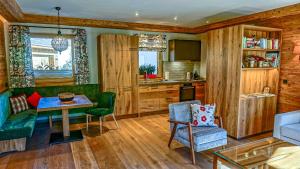 a living room with a table and a kitchen at CHALET KITZBICHL, your Holiday Hideaway by Belle Stay in Reith bei Kitzbühel