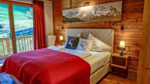 ein Schlafzimmer mit einem Bett mit einer roten Decke in der Unterkunft CHALET KITZBICHL, your Holiday Hideaway by Belle Stay in Reith bei Kitzbühel