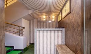 baño con lavabo blanco y pared de madera en Treebo Trend Elite Plaza 700 Mtrs From Madikeri Fort en Madikeri