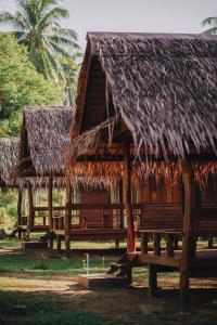 a hut with a straw roof and a bench at COCO Canopy Boutique Resort in Ko Jum