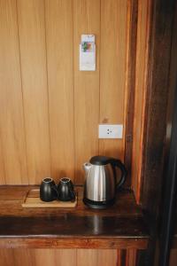 a tea kettle and two mugs on a wooden shelf at COCO Canopy Boutique Resort in Ko Jum