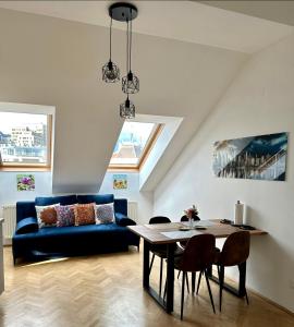 sala de estar con sofá azul y mesa en Dachgeschoss City Apartment in Zentrum Wiens en Viena
