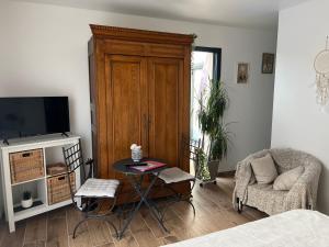 sala de estar con TV, mesa y silla en Quiniere - Entre Lac et Forêt, en Blois