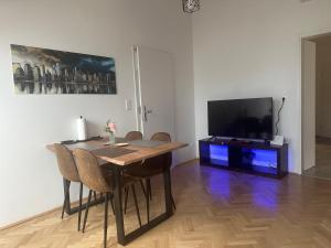 a dining room with a table and a flat screen tv at Dachgeschoss City Apartment in Zentrum Wiens in Vienna