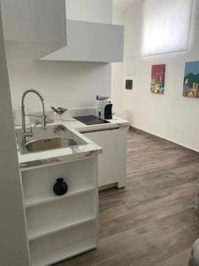 a white kitchen with a sink and a counter at Residenza da Zia Donata in Ercolano +12 photos