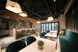 a restaurant with tables and chairs and a bar at R Hotel Namba South in Osaka