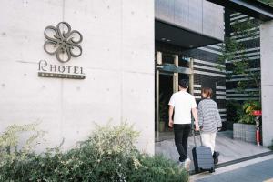 Un uomo e una donna che camminano fuori da un hotel di R Hotel Namba South ad Osaka