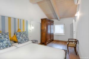 - une chambre avec un lit blanc et une chaise dans l'établissement Casa nel Vicolo - Storie e Dimore, à Chieri