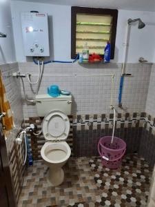 a small bathroom with a toilet and a sink at 2 BHK house, on premise parking, upto 10 guests in Mangalore