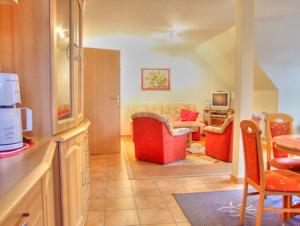 eine Küche und ein Wohnzimmer mit einem Sofa und einem Tisch in der Unterkunft Familienurlaub Natur- & Zentrumsnah im Granitzhof App 03 in Binz