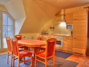 cocina con mesa de madera y sillas en Familienurlaub Natur- & Zentrumsnah im Granitzhof App 03, en Binz