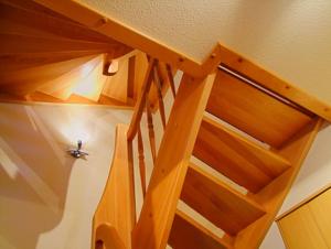 eine Holztreppe in einem Haus mit Holzgeländer in der Unterkunft Familienurlaub Natur- & Zentrumsnah im Granitzhof App 03 in Binz