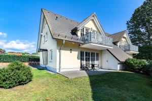 ein weißes Haus mit Balkon und Garten in der Unterkunft Familienurlaub Natur- & Zentrumsnah im Granitzhof App 03 in Binz